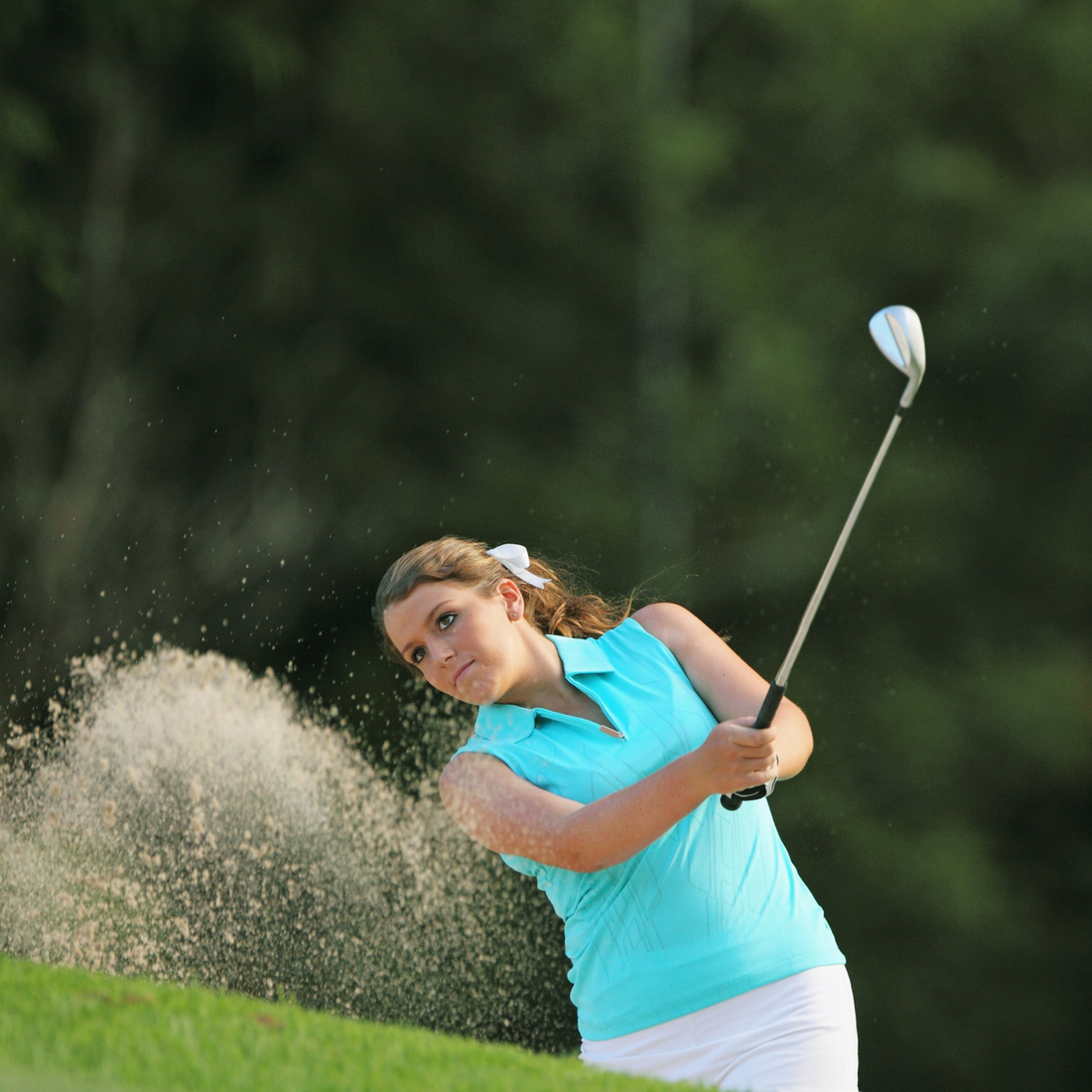 Golfeuse en swing portant une tenue technique chic, illustrant la tendance golfcore printemps-été 2025